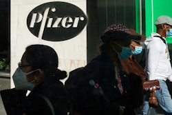 In this Nov. 9, 2020, file photo, pedestrians walk past Pfizer world headquarters in New York. Pfizer announced Wednesday, Nov. 18, 2020, more results in its ongoing coronavirus vaccine study that suggest the shots are 95% effective a month after the first dose.