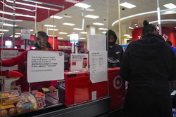 An associate, left, ring customer purchases at a Target store, Tuesday Oct. 20, 2020, in New York. The coronavirus pandemic is transforming holiday hiring this year, with companies starting hiring earlier and offering extra safety protocols. Target said it expects to hire more than 100,000 people for the holiday season.