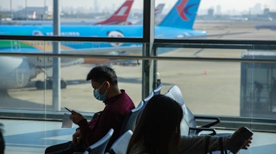 Travelers sit at a boarding gate at Shanghai Hongqiao International Airport in Shanghai, Nov. 6, 2020.