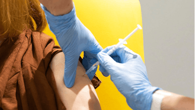 In this undated file photo issued by the University of Oxford, a volunteer is administered the coronavirus vaccine developed by AstraZeneca and Oxford University, in Oxford, England. With major COVID-19 vaccines showing high levels of protection, British officials are cautiously — and they stress cautiously — optimistic that life may start returning to normal by early April. Even before regulators have approved a single vaccine, the U.K. and countries across Europe are moving quickly to organize the distribution and delivery systems needed to inoculate millions of citizens.