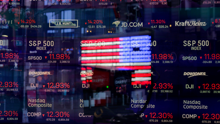 A United States flag reflected in the window of the Nasdaq studio, Times Square, New York, March 16, 2020.