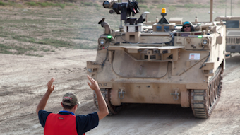 Workers prepare a modified Bradley Fighting Vehicle, known as a Mission Enabling Technologies-Demonstrator, during an exercise at Fort Carson, Colo.