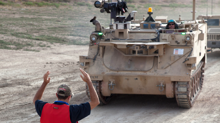 Workers prepare a modified Bradley Fighting Vehicle, known as a Mission Enabling Technologies-Demonstrator, during an exercise at Fort Carson, Colo.