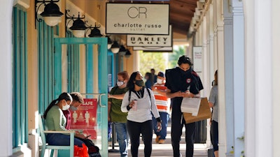 Shoppers wear protective face masks as they look for Black Friday deals at the Ellenton Premium Outlet stores.