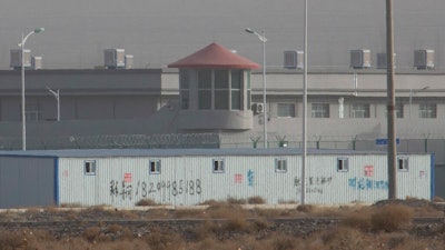 A guard tower and barbed wire fences are seen around a facility in the Kunshan Industrial Park in Artux in western China's Xinjiang region.