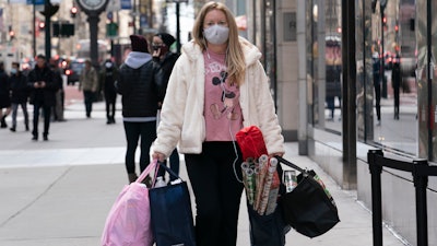 A woman carries shopping bags on Dec. 10 in New York.