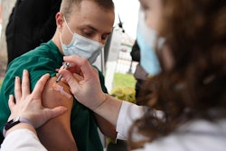 Colleen Teevan, System Pharmacy Clinical Manager at Hartford HealthCare, administers the Pfizer-BioNTech vaccine for COVID-19 to healthcare worker Connor Paleski outside of Hartford Hospital on Monday, Dec. 14 in Hartford, CT.