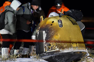 Recovery crew members check on the capsule of the Chang'e 5 probe.