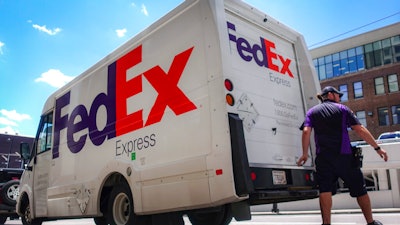 A FedEx delivery truck is loaded by an employee on the street in downtown Cincinnati.