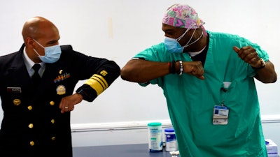 Surgeon General of the U.S. Jerome Adams, left, elbow-bumps Emergency Room technician Demetrius Mcalister.