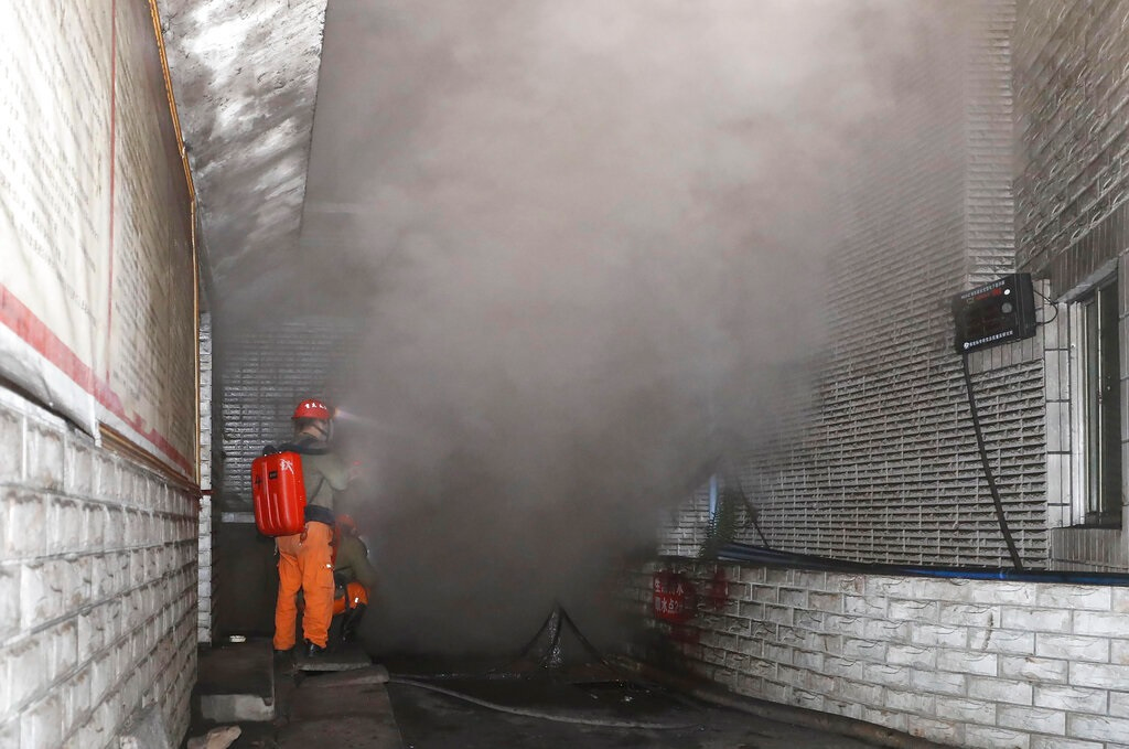 In this photo released by Xinhua News Agency, rescue workers gauge the density of carbon monoxide in the smog at the entrance of the coal mine in Yongchuan District of Chongqing, southwestern China, Friday, Dec. 4, 2020. China's state TV says more than a dozen coal miners have been killed by high levels of carbon monoxide in the country's southwest.