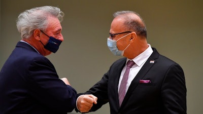 Luxembourg's Foreign Minister Jean Asselborn, left, greets Croatia's Foreign Minister Gordan Grlic Radman with an elbow bump during a meeting of EU Foreign Ministers at the European Council building in Brussels, Monday Dec. 7, 2020. European Union foreign ministers were meeting to discuss making a fresh start to relations with the United States under President-elect Joe Biden, the fallout from weekend elections in Venezuela and tense ties with Turkey.