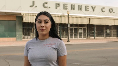 Alexandra Orozco stands for a portrait outside of the closed J.C. Penney where she was laid off from, in Delano, Calif., on Sunday, Dec. 6, 2020. Orozco began working part-time at the department store when she was 18, and in nearly four years rose through the ranks from cashier to freight team associate.