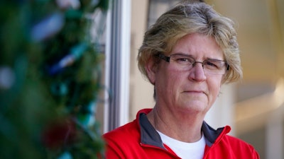 Keli Paaske stands outside her home in Olathe, Kan. Friday, Dec. 4, 2020. Paaske was laid off in August from a company supplying fire doors to hospitals after being furloughed for five months and has struggled to find a new job.