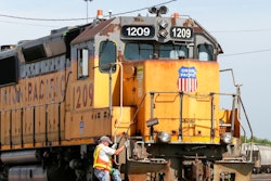In this July 20, 2017, file photo, a Union Pacific employee climbs on board a locomotive in a rail yard in Council Bluffs, Iowa. One of Union Pacific’s main unions is threatening to strike if the railroad doesn’t do more to protect its employees from the coronavirus.