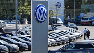 In this April 20, 2020 file photo, a Volkswagen car dealer is open in Essen, Germany. In times when a pandemic unleashes death and poverty, the concept of what is essential to keep society functioning in a lockdown is gripping Europe. What may stay open in one country may be designated as non-essential just across the border.