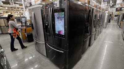 In this Jan. 27, 2020 file photo, a worker pushes a cart past refrigerators at a Home Depot store location in Boston.