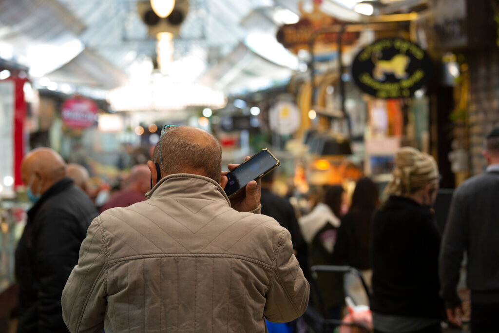A man speaks on his mobile phone in the Mahane Yehuda market in Jerusalem, Dec. 23, 2020.
