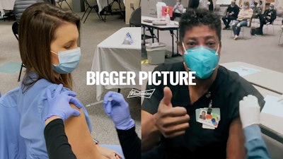 This image provided by Budweiser shows two health care workers getting vaccinated in an advertisement Budweiser is running before the Super Bowl.