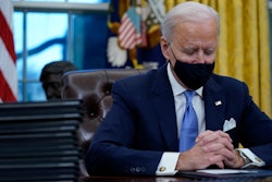 President Joe Biden pauses as he signs his first executive orders in the Oval Office of the White House on Wednesday, Jan. 20, 2021, in Washington.
