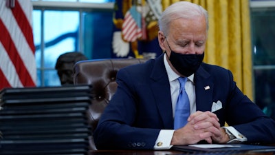 President Joe Biden pauses as he signs his first executive orders in the Oval Office of the White House on Wednesday, Jan. 20, 2021, in Washington.