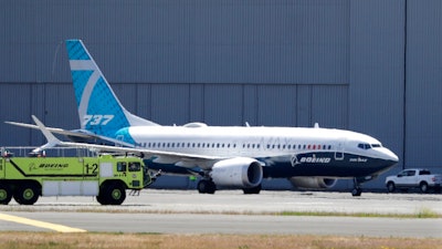 In this Monday, June 29, 2020, file photo, A Boeing 737 MAX jet taxis after landing at Boeing Field following a test flight in Seattle. Boeing will pay $2.5 billion to settle a criminal charge related to its troubled 737 Max jetliner. The Justice Department announced the settlement Thursday, Jan. 7, 2021 nearly two years after the second of two crashes that killed 346 people in all.