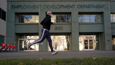 In this file photo, a runner passes the office of the California Employment Development Department in Sacramento.