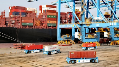 Automated vehicles move shipping containers in a container port in Qingdao in eastern China's Shandong Province. The U.S.-Chinese trade war isn't going away under President Joe Biden.