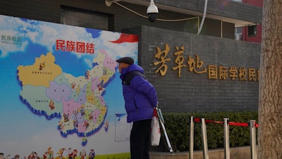 An elderly Chinese man looks at map of Chinese showing its different ethnic groups and the slogan 'Ethnic Unity' in Beijing, China Monday, Jan. 11, 2021. A Chinese official on Monday denied Beijing has imposed coercive birth control measures among Muslim minority women, following an outcry over a tweet by the Chinese Embassy in Washington claiming that government polices had freed women of the Uighur ethnic group from being 'baby-making machines.'