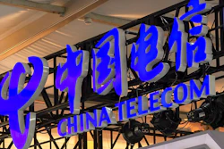 In this Sept. 5, 2020, file photo, the logo for Chinese telecommunications firm China Telecom is seen on a booth at the China International Fair for Trade in Services (CIFTIS) in Beijing. The New York Stock Exchange says it no longer plans to remove shares of three Chinese state-owned phone carriers under an order by President Donald Trump.