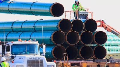 In this May 9, 2015, file photo, workers unload pipes in Worthing, S.D., for the Dakota Access oil pipeline that stretches from the Bakken oil fields in North Dakota to Illinois. A federal appeals court on Tuesday, Jan. 26, 2021, upheld the ruling of a district judge who ordered a full environmental impact review of the Dakota Access pipeline in North Dakota. Following a complaint by the Standing Rock Sioux Tribe, U.S. District Judge James Boasberg said in April 2020 that a more extensive review was necessary than the one already conducted by the U.S. Army Corps of Engineers.