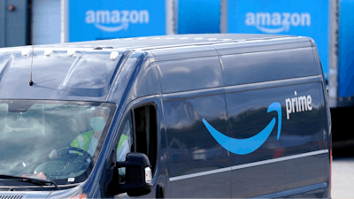 In this file photo, an Amazon Prime logo appears on the side of a delivery van as it departs an Amazon Warehouse. Online shopping has been a lifeline for many as the virus pandemic shuttered stores and kept people at home.