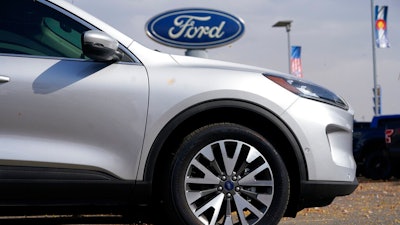 In this Sunday, Oct. 11, 2020 file photo, A row of 2020 Ford Escape sports-utility vehicles sits at a Ford dealership in Denver. A widening global shortage of semiconductors for auto parts is forcing major auto companies to halt or slow vehicle production just as they were recovering from pandemic-related factory shutdowns. Ford had scheduled down time next week at its Louisville, Kentucky, assembly plant, but moved it ahead to this week. The plant makes the Ford Escape and Lincoln Corsair small SUVs.