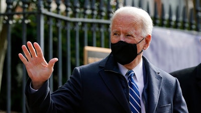 President Joe Biden waves as he departs after attending Mass at Holy Trinity Catholic Church, Sunday, Jan. 24, 2021, in the Georgetown neighborhood of Washington. Biden plans to sign an executive order Monday, Jan. 25 that aims to boost government purchases from U.S. manufacturers.