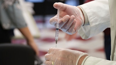 CVS Pharmacist Gerard Diebner prepares a shot of the COVID-19 vaccine for the nursing home residents at Harlem Center for Nursing and Rehabilitation.