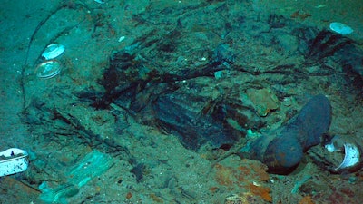 This 2004 photo provided by the Institute for Exploration, Center for Archaeological Oceanography/University of Rhode Island/NOAA Office of Ocean Exploration, shows the remains of a coat and boots in the mud on the sea bed near the Titanic's stern. Fallout from the coronavirus pandemic is threatening a company’s plans to retrieve and exhibit the radio that had broadcast distress calls from the sinking vessel, according to a court filing made by the firm on Monday, Jan. 11, 2021.