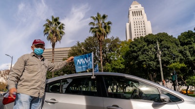 Uber driver Jose Luis Guevara, a member of the Mobile Workers Alliance, pauses for a picture outside Los Angeles City Hall. Drivers for app-based ride-hailing and delivery services are suing to overturn a California ballot initiative.