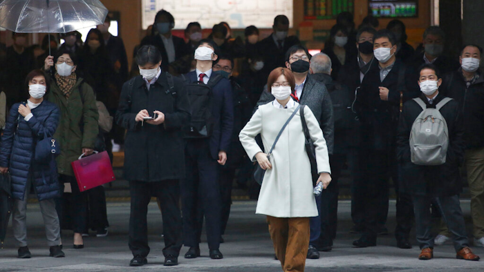 People wait at a crossing in Tokyo, Feb. 15, 2021.