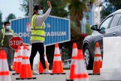 Cars are waved in as people arrive to receive the COVID-19 vaccine at Dodger Stadium, Los Angeles, Feb. 1, 2021.