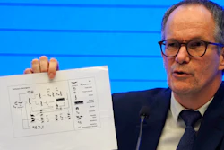 Peter Ben Embarek of the World Health Organization holds up a chart showing pathways of transmission of the virus during a press conference in Wuhan, Feb. 9, 2021.