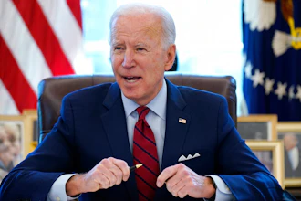 In this Jan. 28, 2021 file photo, President Joe Biden signs a series of executive orders in the Oval Office of the White House in Washington.