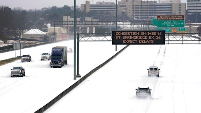 An electronic message board advises drivers of potential congestion on the intersecting interstate as they drive south on Interstate 55 in north Jackson, MS on Feb. 15 as light snow mixed with sleet, and rain continue to cover much of the state.
