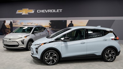 The 2022 Bolt EV, foreground, and EUV are displayed, Thursday, Feb. 11, 2021, in Milford, Michigan.