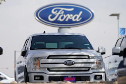 In this file photo vehicles sit at a dealership in Denver. Ford Motor Co. lost $1.28 billion last year as it dealt with the coronavirus pandemic.