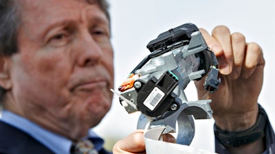 In this April 1, 2014, file photo, Clarence Ditlow, executive director of the Center for Auto Safety, displays a GM ignition switch similar to those linked to 13 deaths and dozens of crashes of General Motors small cars like the Chevy Cobalt, during a news conference on Capitol Hill in Washington. General Motors Co., has agreed to a $5.75 million settlement with California regarding false statements the company made to investors about problems with its deadly ignition switches, state officials announced Friday, Feb. 12, 2021. The faulty ignition switches led to at least 124 fatalities and 274 injuries nationwide.