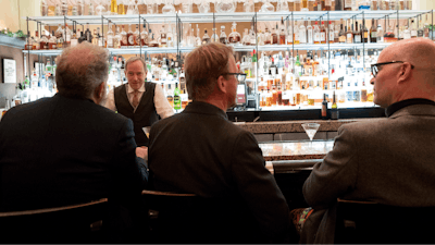 In this file photo, a bartender talks to a customer at the Gotham Bar and Grill in New York.