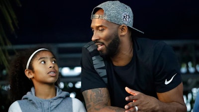 In this July 26, 2018, file photo, former Los Angeles Laker Kobe Bryant and his daughter Gianna watch the U.S. national championships swimming meet in Irvine, Calif. Federal safety officials are expected to vote Tuesday, Feb. 9, 2021, on what likely caused the helicopter carrying Kobe Bryant, his 13-year-old daughter and seven others to crash into a Southern California hillside last year, killing all aboard.