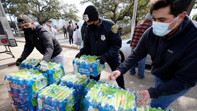 Donated water is distributed to residents, Thursday, Feb. 18, 2021, in Houston. Houston and several surrounding cities are under a boil water notice as many residents are still without running water in their homes.