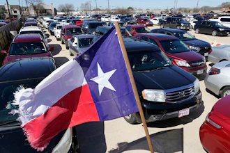 Hundreds of a vehicles are staged in a parking lot as people wait in line at a food and water distribution site in Houston.
