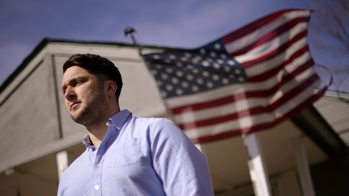 Logan DeWitt stands outside his home in Kansas City, Kansas.